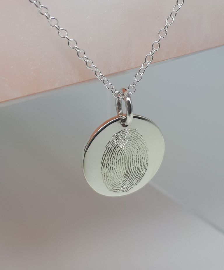 Sterling silver fingerprint charm on a chain.